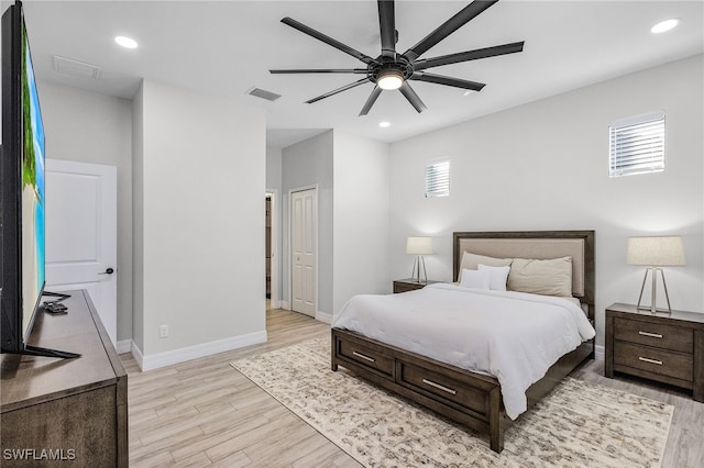 bedroom with multiple windows, light wood-type flooring, and ceiling fan