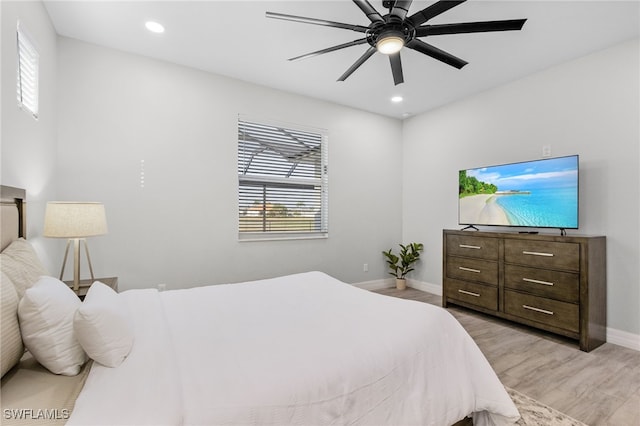 bedroom featuring light hardwood / wood-style floors, multiple windows, and ceiling fan