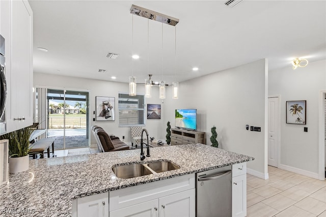 kitchen featuring light stone counters, sink, pendant lighting, and white cabinets