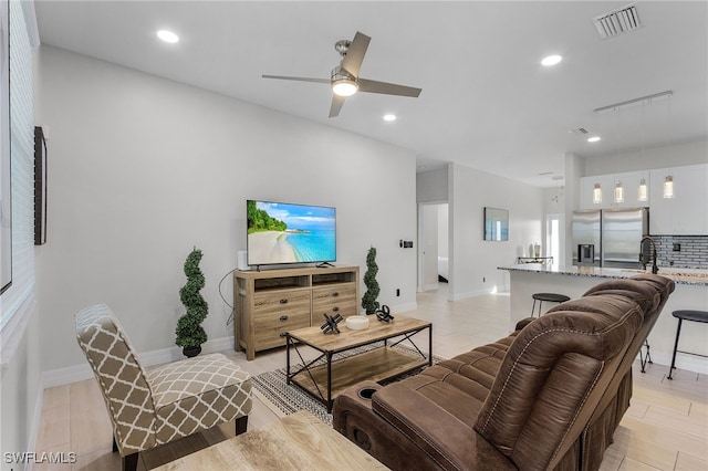 living room featuring light wood-type flooring and ceiling fan