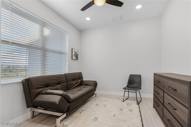 living room featuring light hardwood / wood-style flooring and ceiling fan