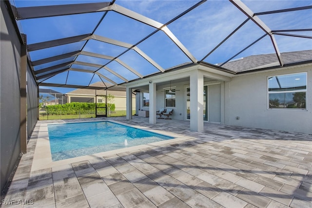 view of swimming pool featuring a patio, ceiling fan, pool water feature, and glass enclosure