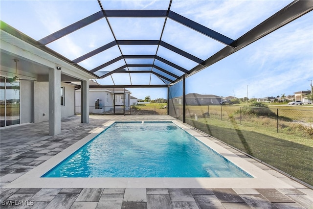 view of pool featuring a patio area, a lanai, a lawn, and pool water feature