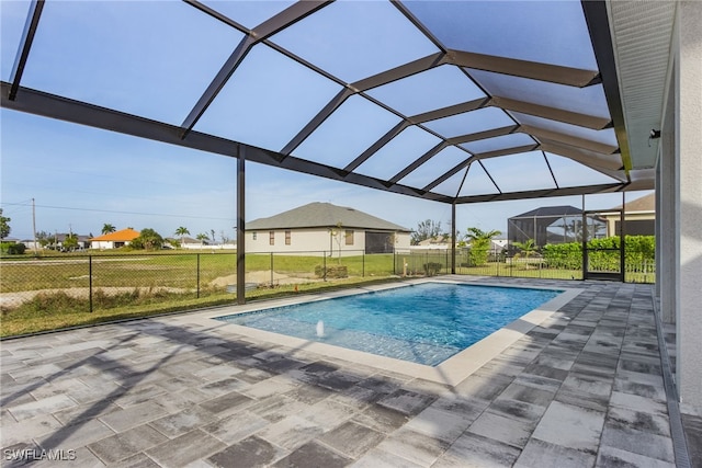 view of pool featuring a lawn, pool water feature, a patio area, and glass enclosure