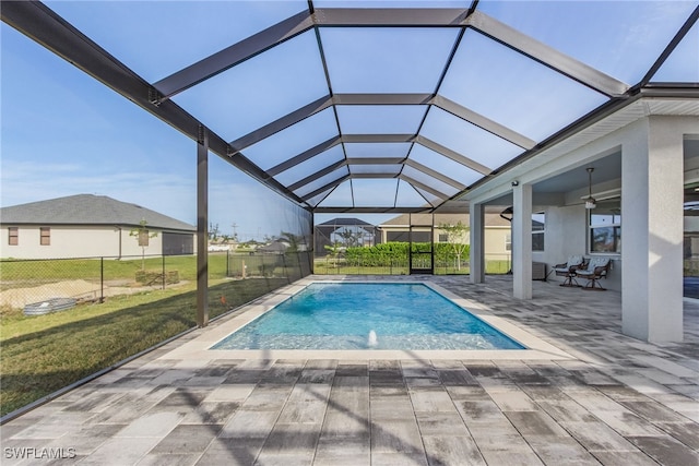 view of swimming pool with pool water feature, a patio area, a lanai, and a lawn