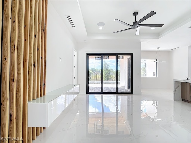 empty room featuring a raised ceiling and ceiling fan