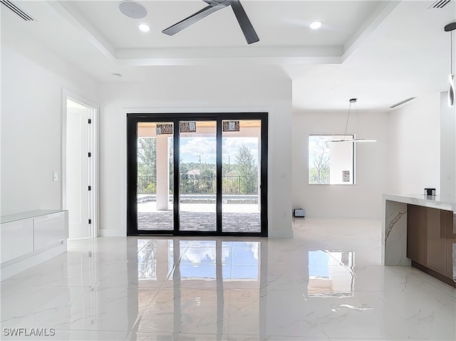 empty room featuring ceiling fan and a tray ceiling