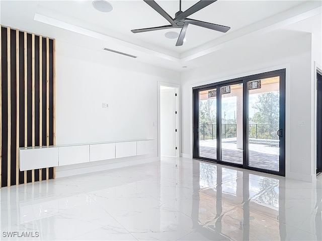 unfurnished room with a raised ceiling and ceiling fan