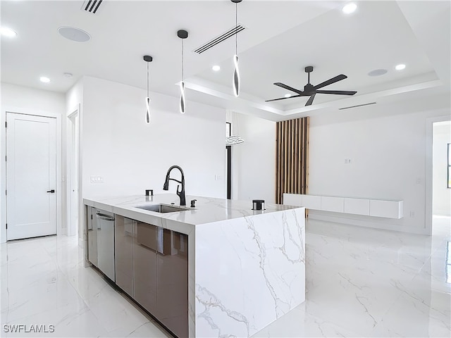 kitchen featuring pendant lighting, a spacious island, sink, ceiling fan, and a tray ceiling