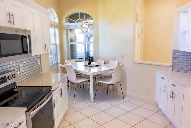 kitchen featuring white cabinetry, a healthy amount of sunlight, appliances with stainless steel finishes, and light tile patterned floors