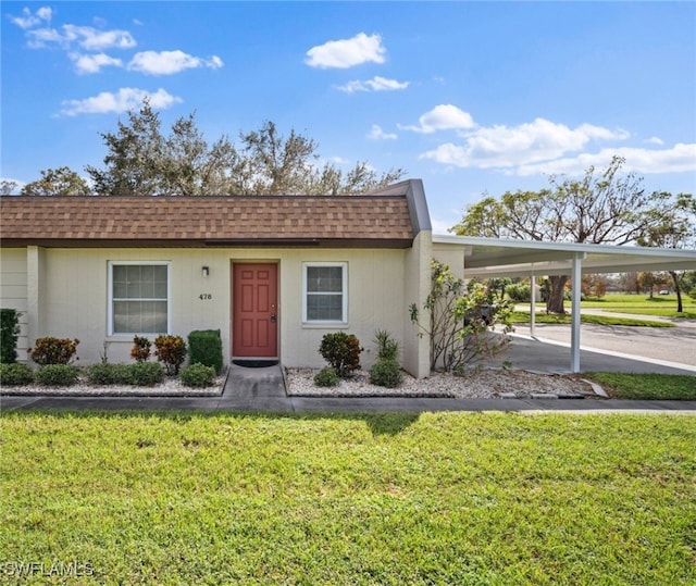 ranch-style home with a carport and a front yard