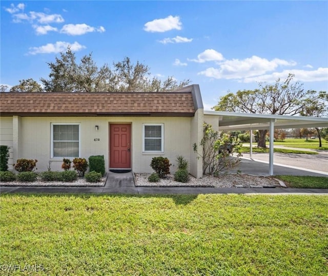 6300 S Pointe Blvd Unit 478, Fort Myers, FL 33919 - view of front of home with a shingled roof, a front lawn, concrete driveway, and a carport