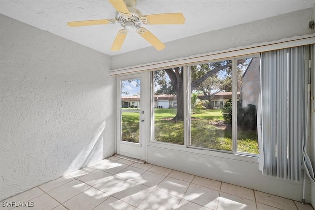 unfurnished sunroom featuring ceiling fan