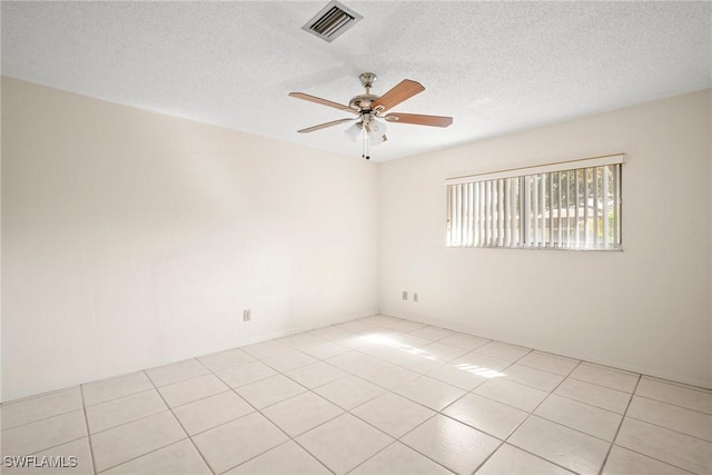 tiled empty room featuring ceiling fan and a textured ceiling