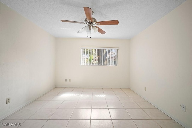 tiled spare room with a textured ceiling and ceiling fan