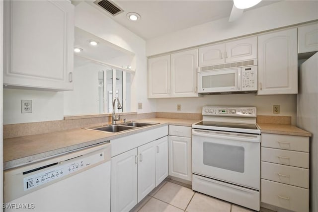 kitchen featuring sink, white cabinets, light tile patterned flooring, and white appliances