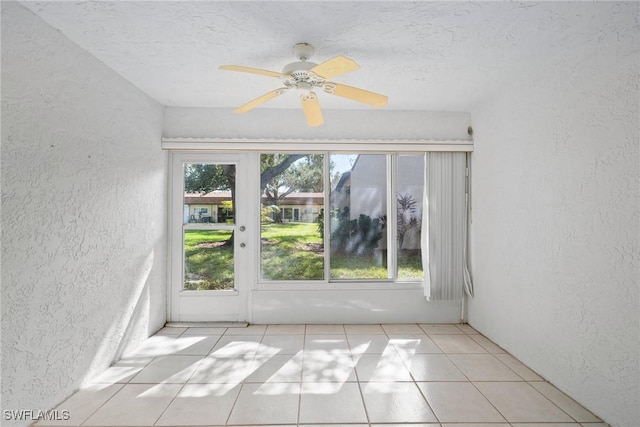 tiled empty room featuring ceiling fan