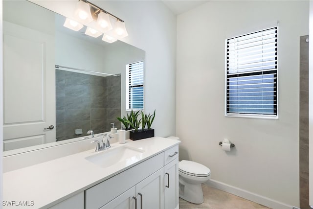 bathroom with vanity, toilet, a healthy amount of sunlight, and a tile shower