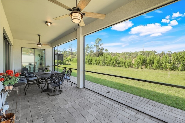 sunroom featuring ceiling fan