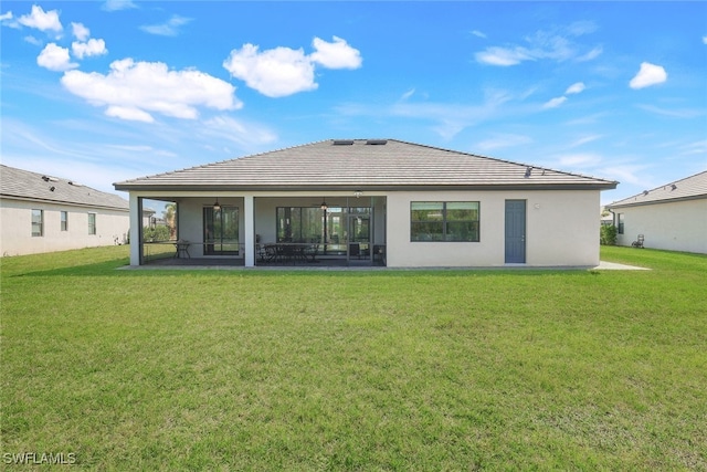 rear view of property featuring a patio area and a lawn