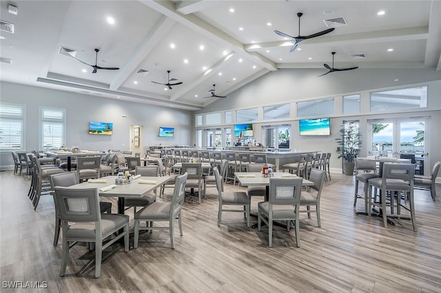 dining space with hardwood / wood-style floors, a healthy amount of sunlight, high vaulted ceiling, and ceiling fan