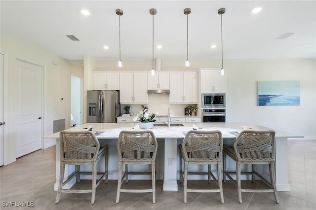 kitchen featuring a large island, white cabinets, decorative light fixtures, and stainless steel appliances