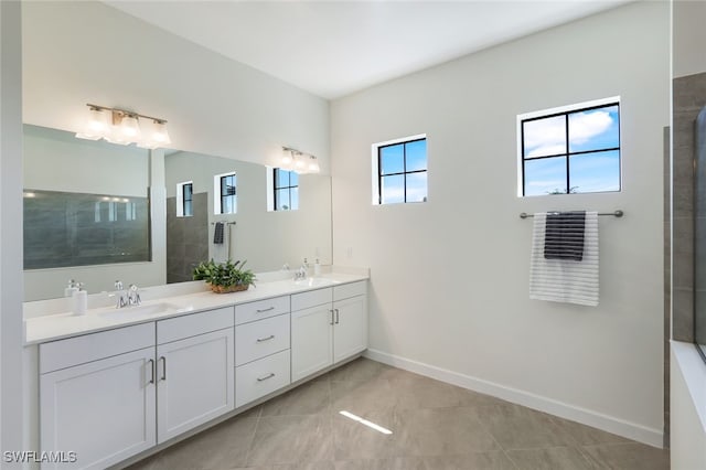 bathroom featuring vanity, a healthy amount of sunlight, tile patterned floors, and tiled shower