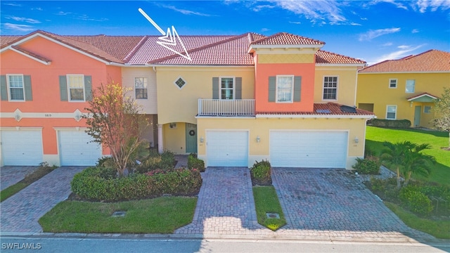 view of front of home featuring a front yard, a garage, and a balcony