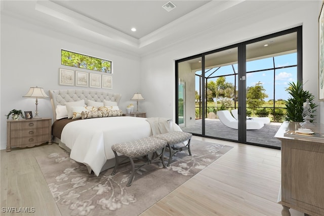 bedroom featuring a raised ceiling, access to outside, crown molding, and light hardwood / wood-style floors