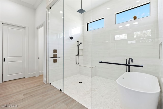 bathroom with shower with separate bathtub, hardwood / wood-style flooring, and crown molding