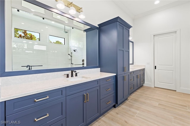 bathroom featuring vanity, hardwood / wood-style flooring, walk in shower, and ornamental molding