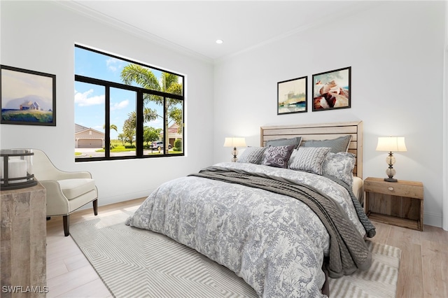 bedroom featuring light hardwood / wood-style flooring and crown molding