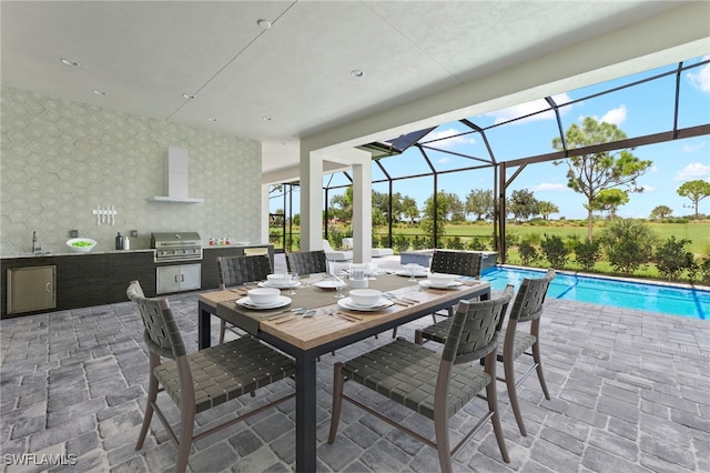 view of patio / terrace with sink, glass enclosure, area for grilling, and exterior kitchen