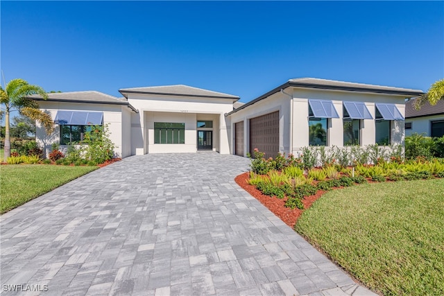 view of front of home featuring a front yard and a garage