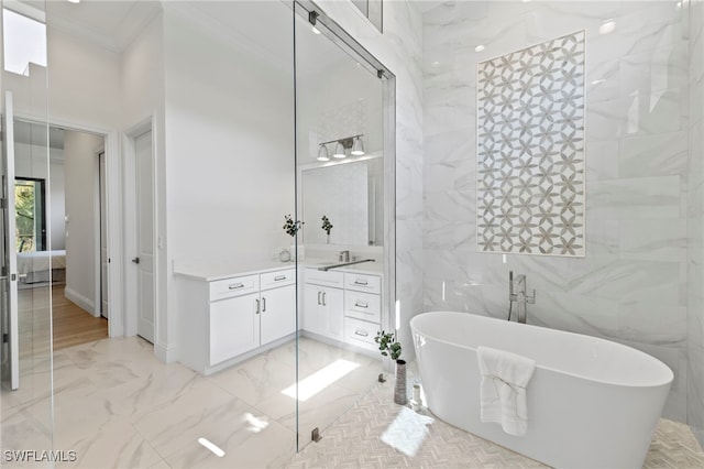 bathroom featuring vanity, a bathtub, crown molding, and tile walls