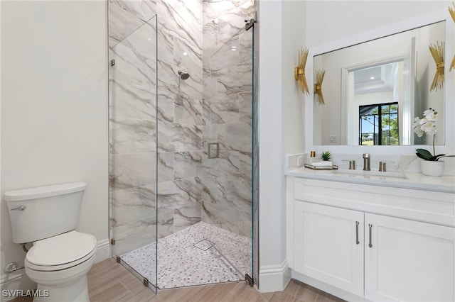 bathroom with vanity, hardwood / wood-style flooring, toilet, and a shower with door