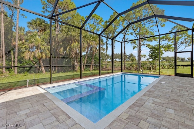 view of pool with glass enclosure and a patio area