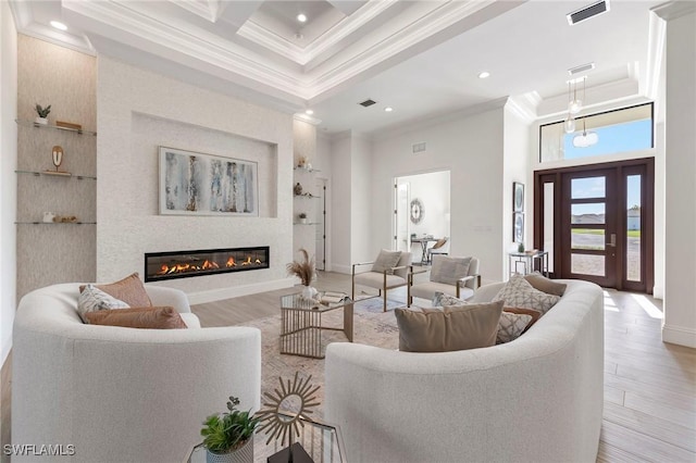 living room featuring beam ceiling, light hardwood / wood-style flooring, a towering ceiling, and ornamental molding