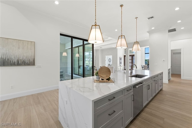 kitchen with stainless steel dishwasher, gray cabinetry, sink, a center island with sink, and light hardwood / wood-style floors