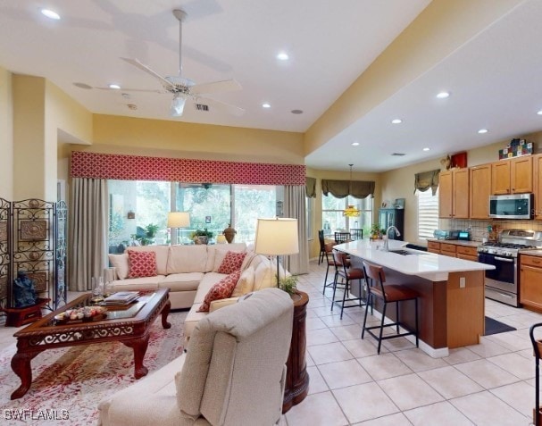 living room with sink, ceiling fan, and light tile patterned flooring