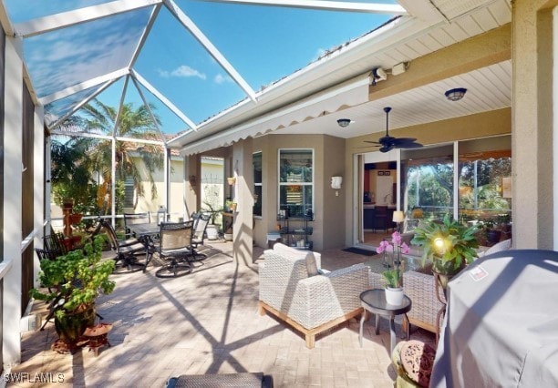 view of patio / terrace with ceiling fan and glass enclosure