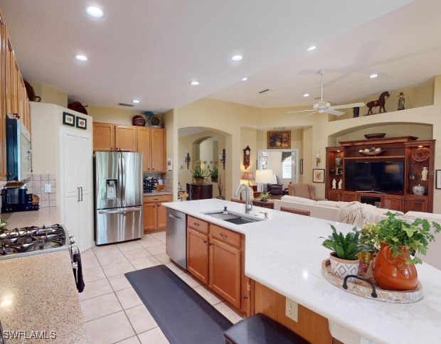 kitchen with ceiling fan, stainless steel appliances, sink, and backsplash