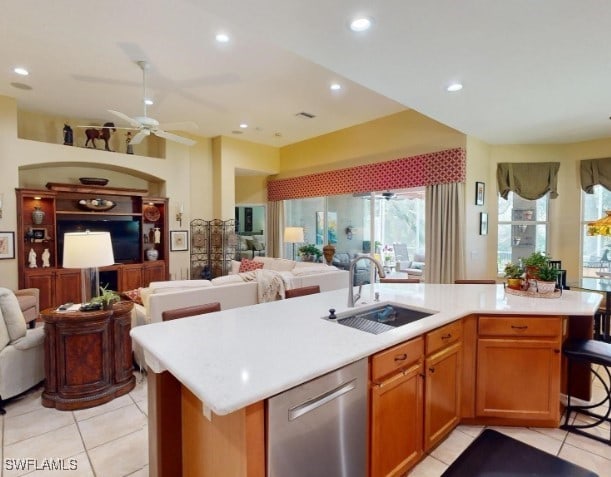 5291 Laurel Oak Ct, North Port, FL 34287 - kitchen featuring stainless steel dishwasher, a sink, light countertops, open floor plan, and light tile patterned flooring