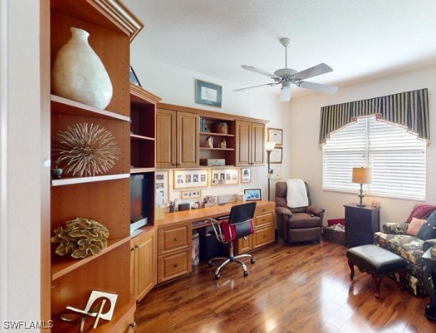 office space featuring built in desk, ceiling fan, and hardwood / wood-style floors