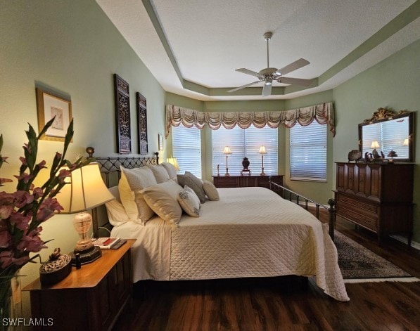 5291 Laurel Oak Ct, North Port, FL 34287 - bedroom featuring a ceiling fan, wood finished floors, a tray ceiling, and multiple windows