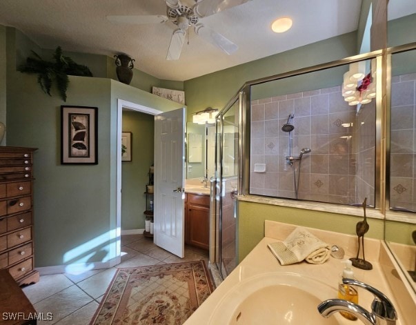 bathroom featuring a shower with door, ceiling fan, tile patterned floors, and vanity