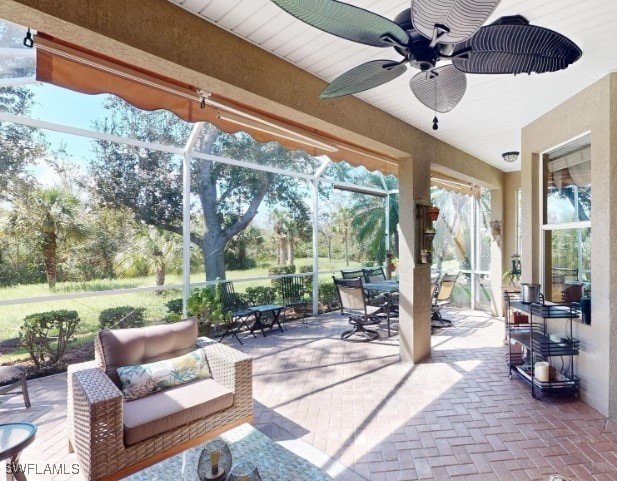 view of patio with glass enclosure and ceiling fan