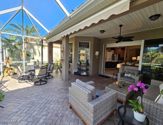 5291 Laurel Oak Ct, North Port, FL 34287 - view of patio / terrace featuring a ceiling fan, outdoor dining space, an outdoor living space, and glass enclosure