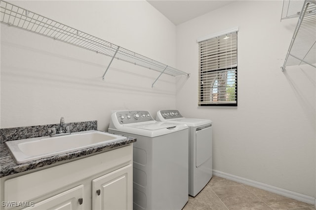 laundry room with sink, light tile patterned floors, washer and clothes dryer, and cabinets