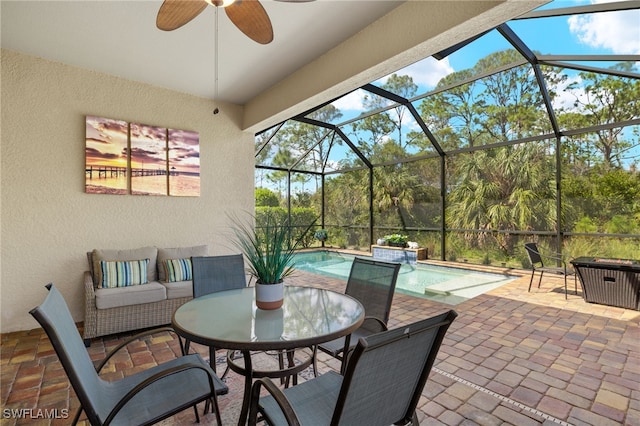 view of patio / terrace with ceiling fan, an outdoor living space, and glass enclosure